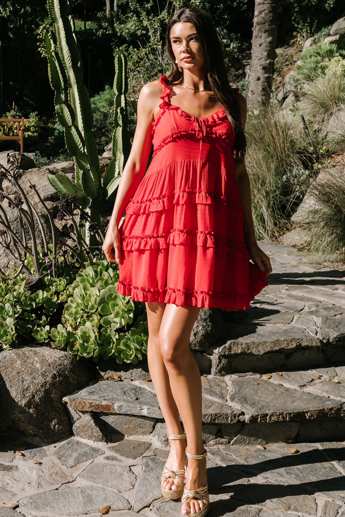 Model wearing red Andalucía short dress, full-length shot highlighting tiered skirt movement and lined construction to last tier.