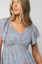 Close-up of smocked center-seamed bodice and upturned V high waist showing elastic smocking and fabric texture in dusty blue.