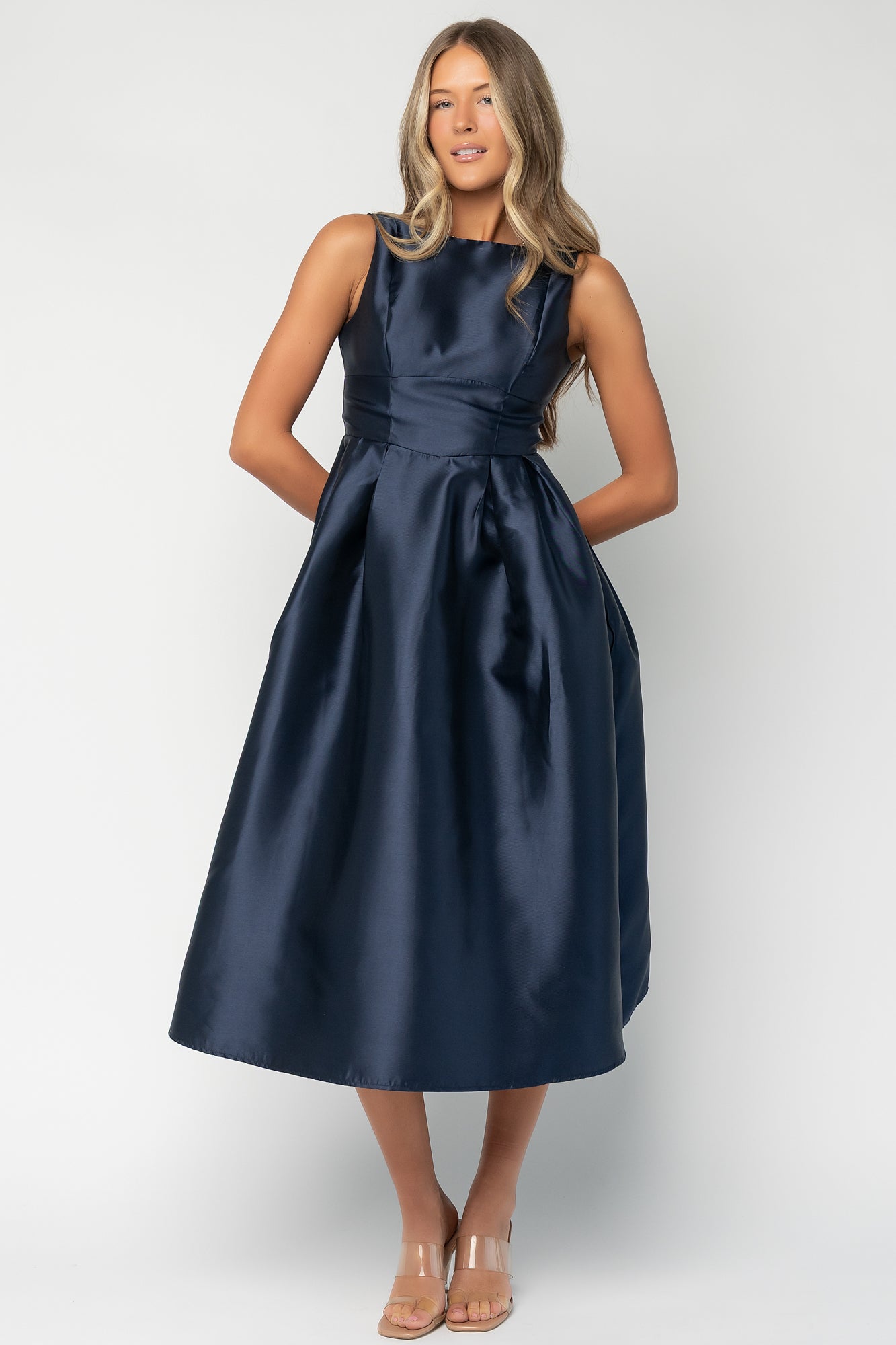 Studio shot of navy dress fabric and pockets; captures subtle sheen and tailored seams for formal occasion wear.