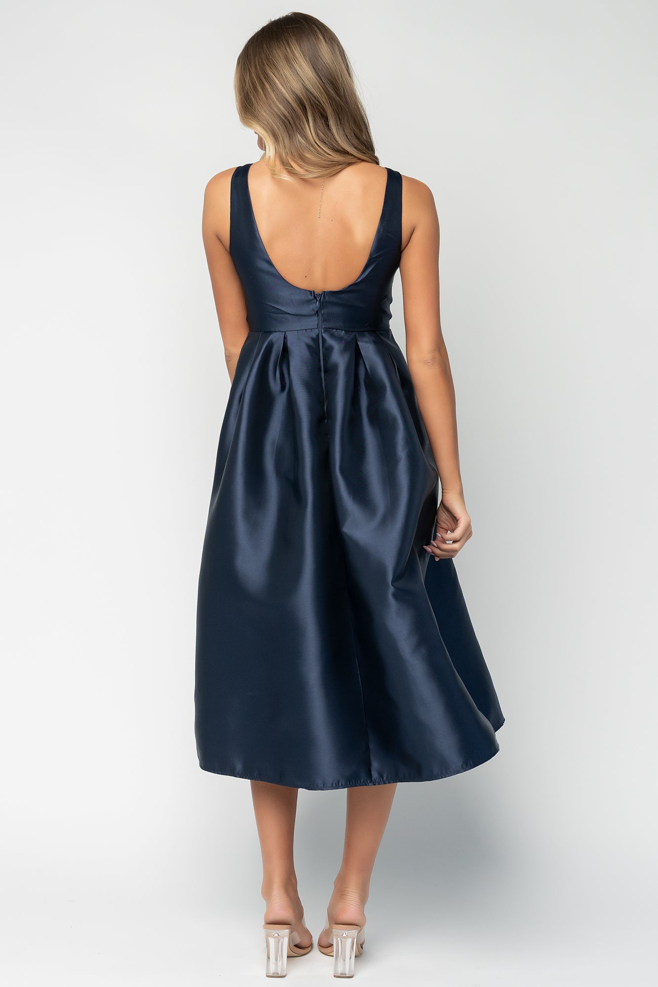 Side angle showing box pleats under the waist, A-line midi skirt silhouette, and the placement of the side pockets.