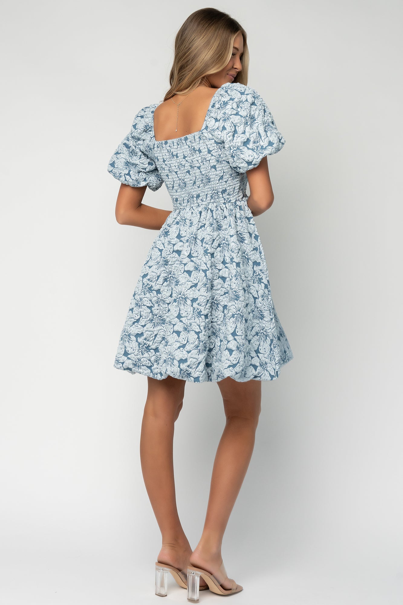 Detail shot of the short puffed sleeve and square neckline showing sleeve volume and elegant seam finishes on the bodice.