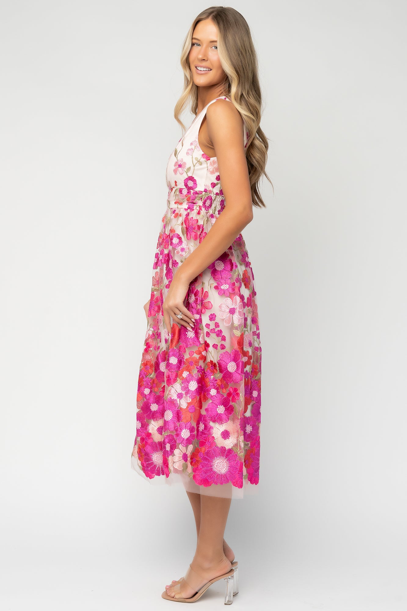 Model wearing Lila Embroidered Midi Dress in pink floral: full-length view showing fit, V-neck, tank sleeves, and elegant midi hem movement.