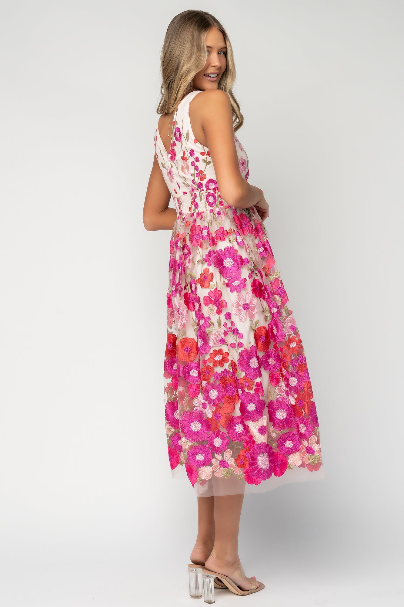 Back view of Lila Embroidered Midi Dress showing smocked waistband, tank-style straps, and the layered tulle skirt silhouette in pink floral.