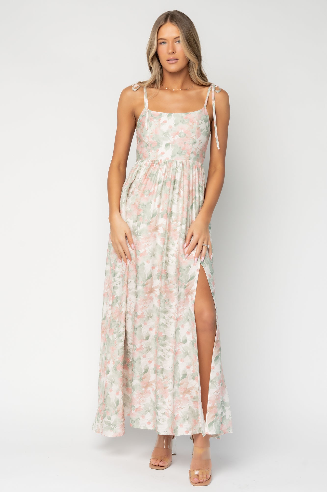Front view of model wearing Elton Maxi Dress in sage and blush floral, showing slight swoop neckline, adjustable straps, and full skirt drape.