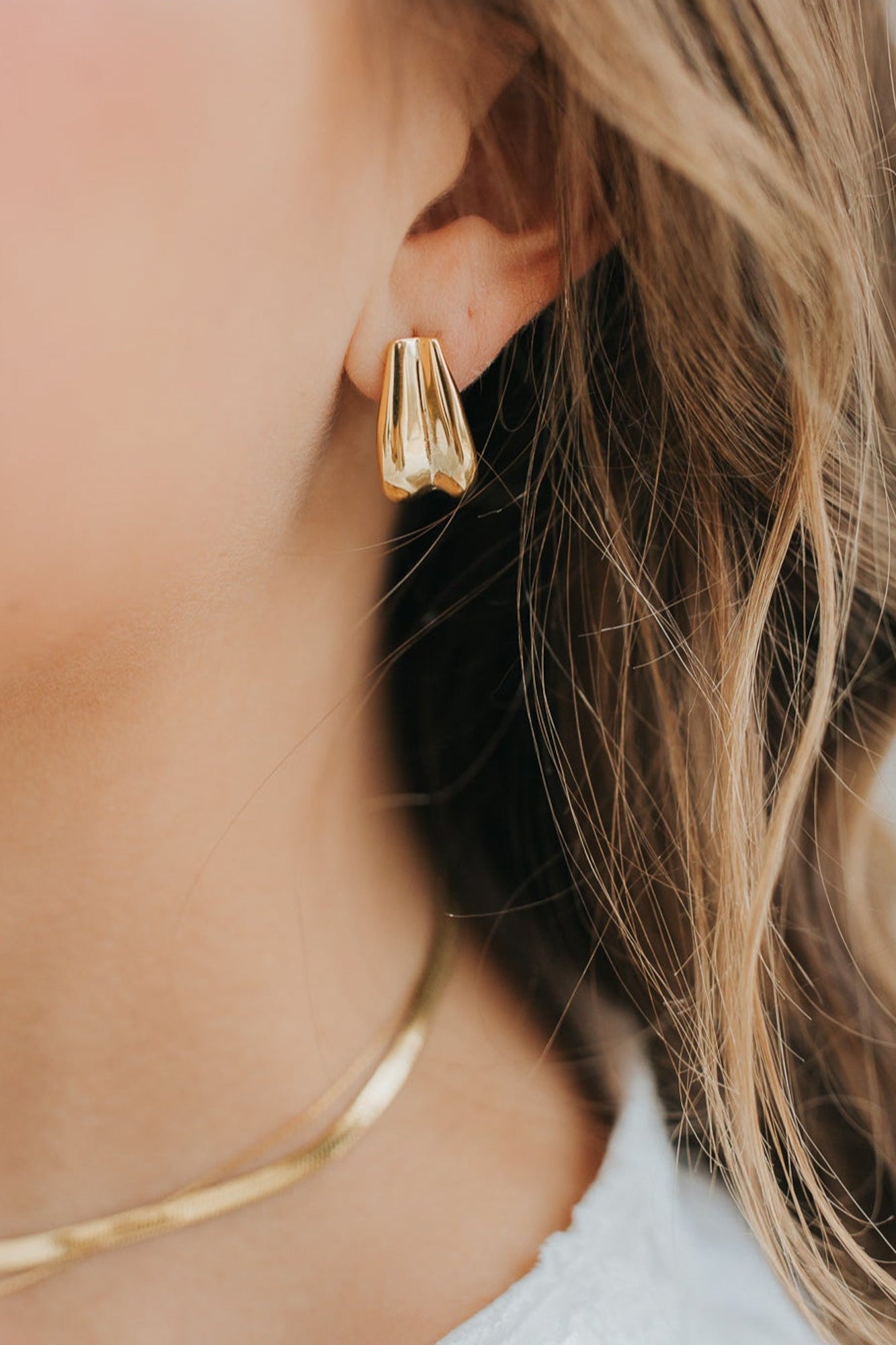 Front view of The Sicily Hoop pair in gold plating, highlighting the sculptural folded-metal shape and polished, tarnish-resistant finish.