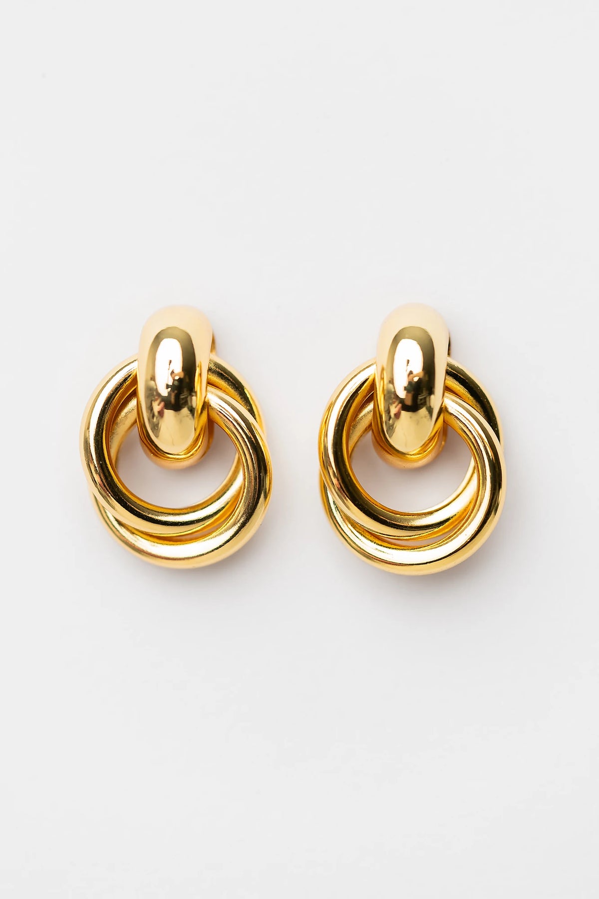 Abby Statement Earrings in Gold with polished gold-tone finish, layered circular design, and sculptural silhouette.