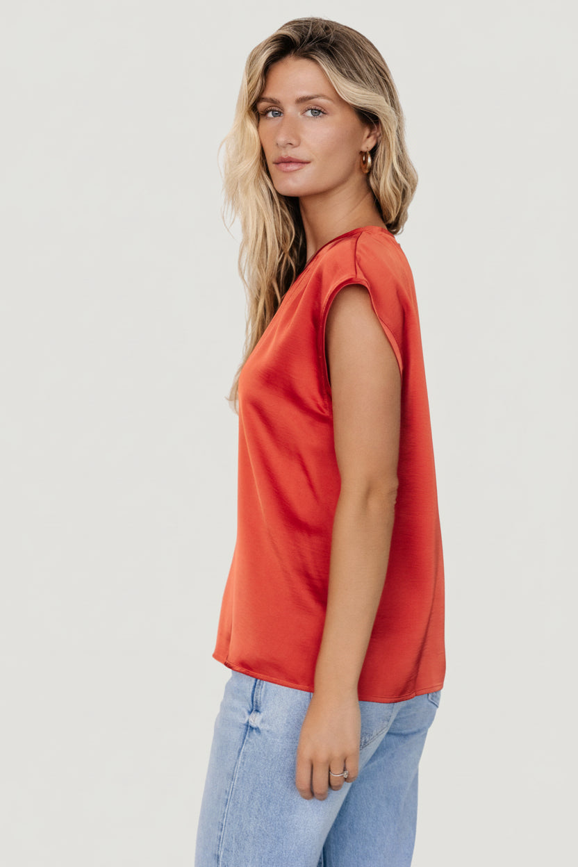 Close-up of Adina Top fabric in rust color highlighting subtle sheen and smooth texture; no visible stretch in the material.