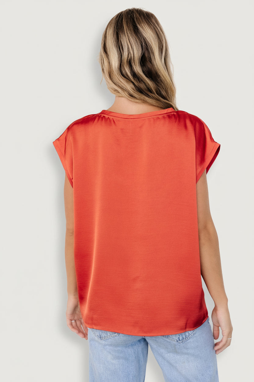 Styled flatlay of Adina Top in rust paired with neutral accessories and denim; showcases color, shape, and styling possibilities.