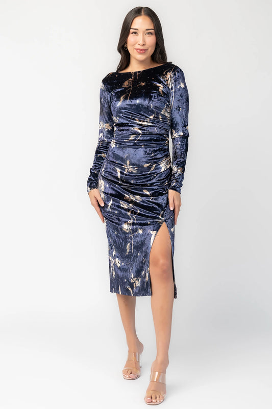 Afterglow Velvet Midi Dress in Navy + Gold with metallic florals, boat neckline, long sleeves, and side draping.