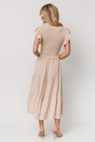 Back view of Afton tiered midi dress in sand showing tiered skirt panels and lightweight, unlined construction.
