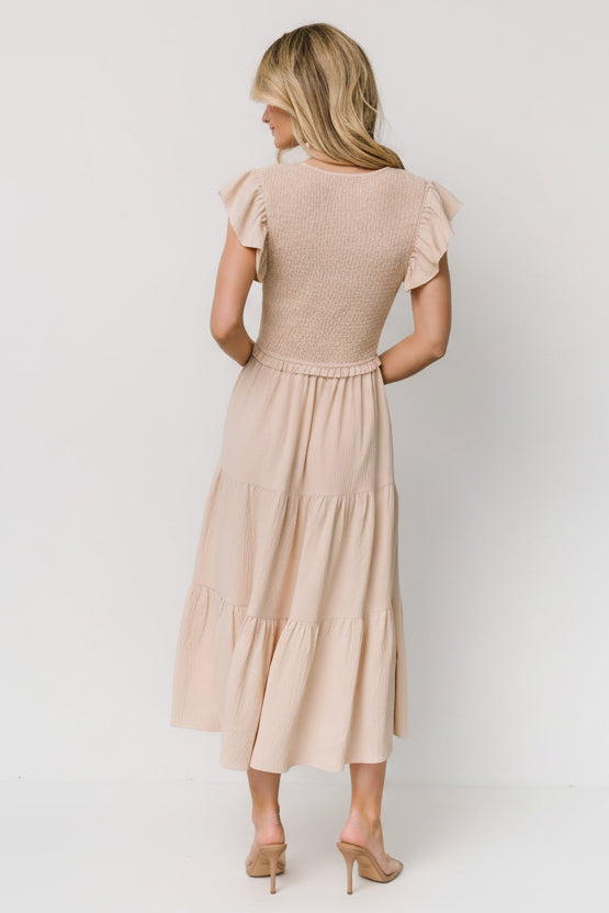 Back view of Afton tiered midi dress in sand showing tiered skirt panels and lightweight, unlined construction.
