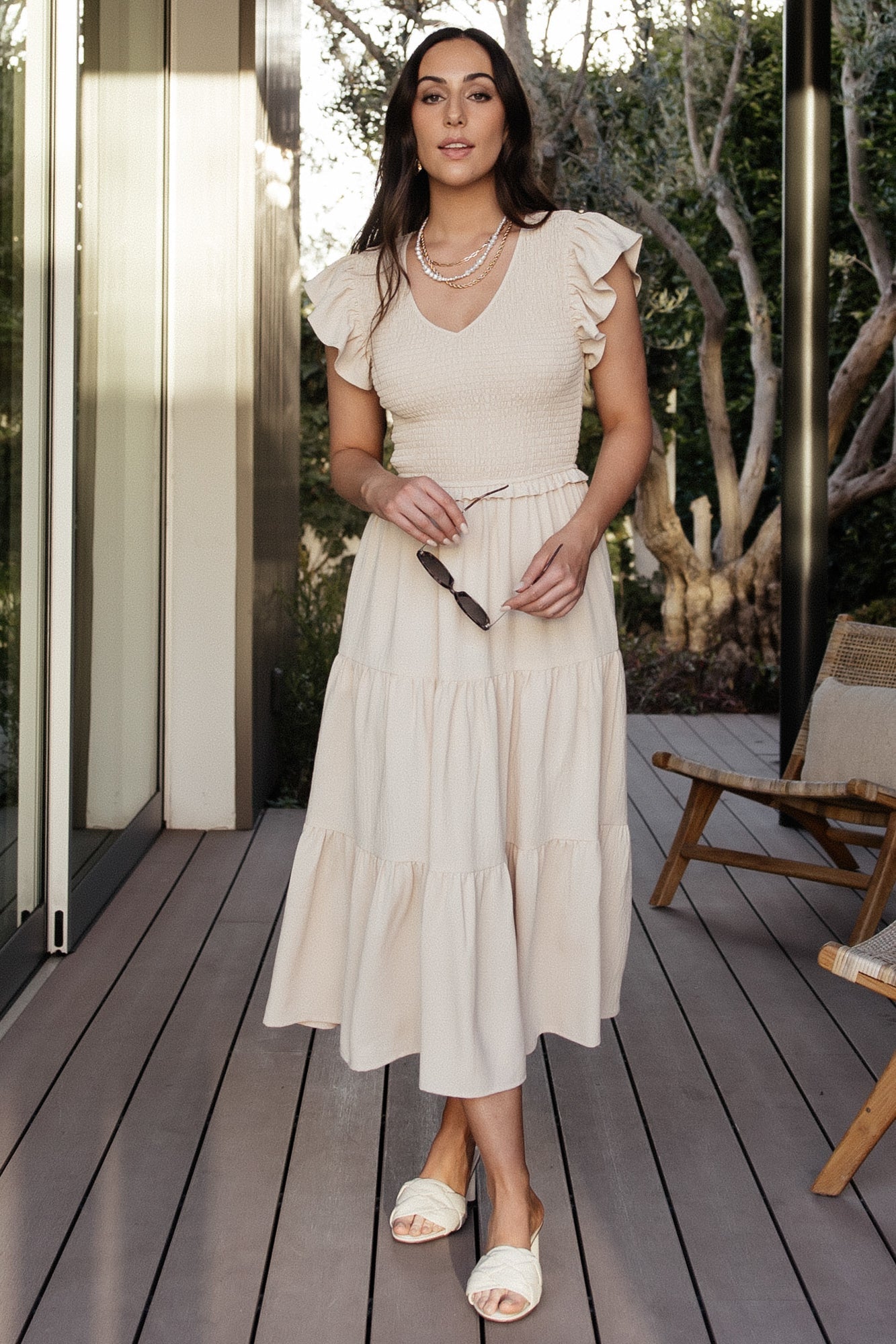 Close-up of smocked bodice and V-neck on the Afton dress in sand, showing stretch detail and fabric texture.