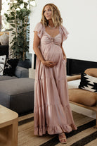 Side profile of Agatha Maxi Dress in dusty mauve on model highlighting short ruffle sleeve, smocked back and tiered skirt silhouette.