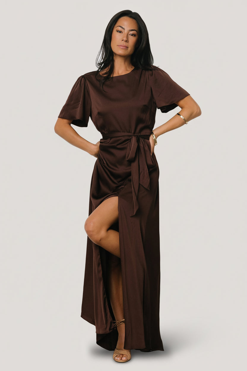 Close-up of the Agnes satin dress in espresso showing fabric sheen, gentle drape, and natural waist with removable belt tie.