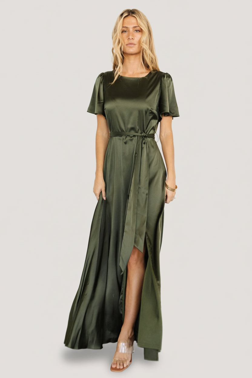 Three-quarter view of Agnes satin maxi in juniper green highlighting flutter sleeves, smooth satin sheen, and flowing skirt movement.