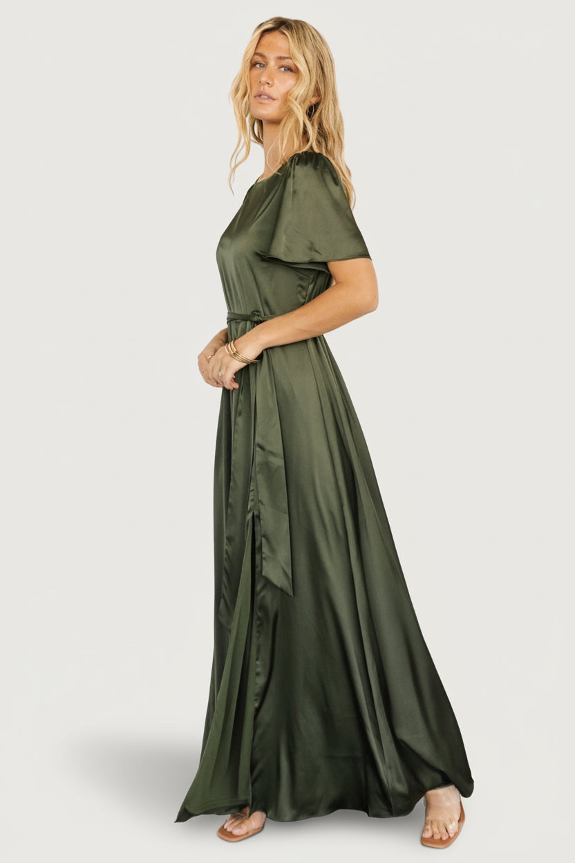 Studio shot of Agnes satin maxi in juniper green on model, highlighting full maxi length and elegant silhouette suitable for events.