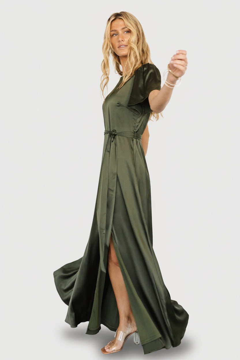 Lifestyle image of the Agnes dress in juniper green showcasing flutter sleeve detail and natural waist fit on a moving model.