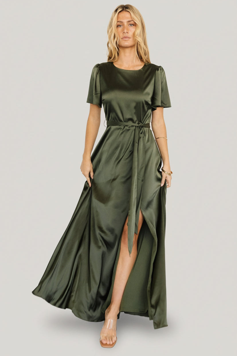 Front view of Agnes satin maxi dress in juniper green on model, showing rounded neckline and removable waist tie, full-length drape.