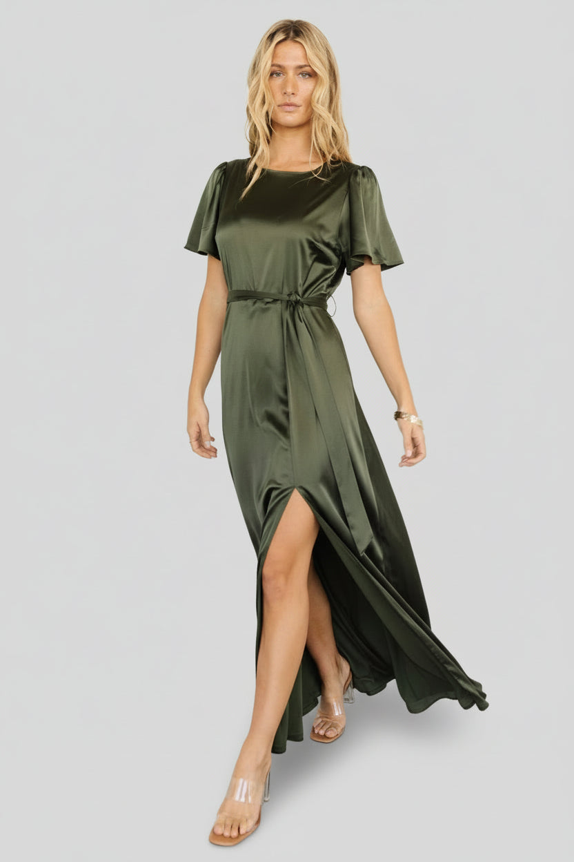 Full-length shot of the Agnes satin maxi dress in juniper green on model, exhibiting flow, slit detail, and elegant event-ready styling.