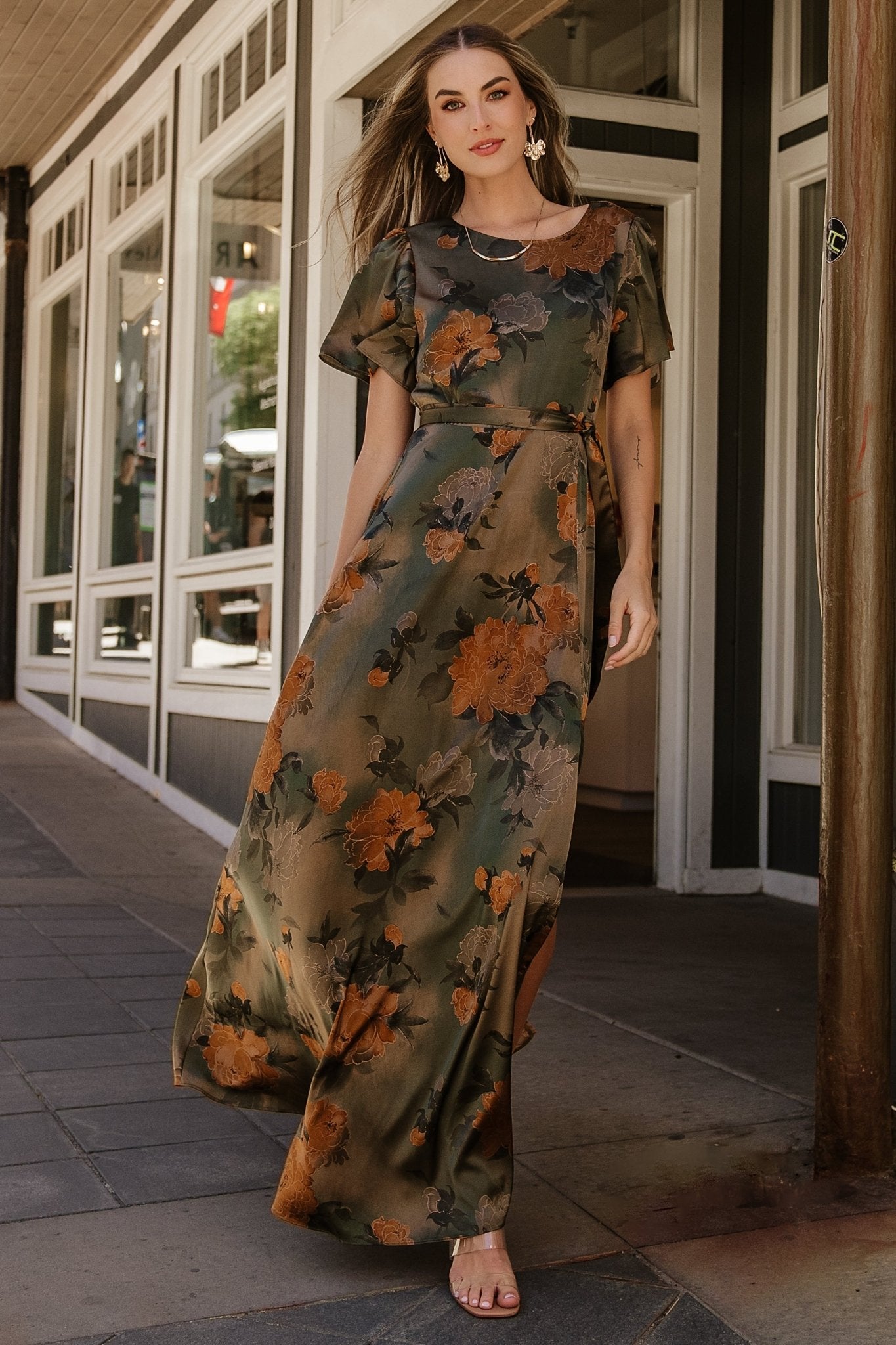 Back view of olive floral satin maxi dress highlighting keyhole button at back neck and elastic back waist for flexible fit.