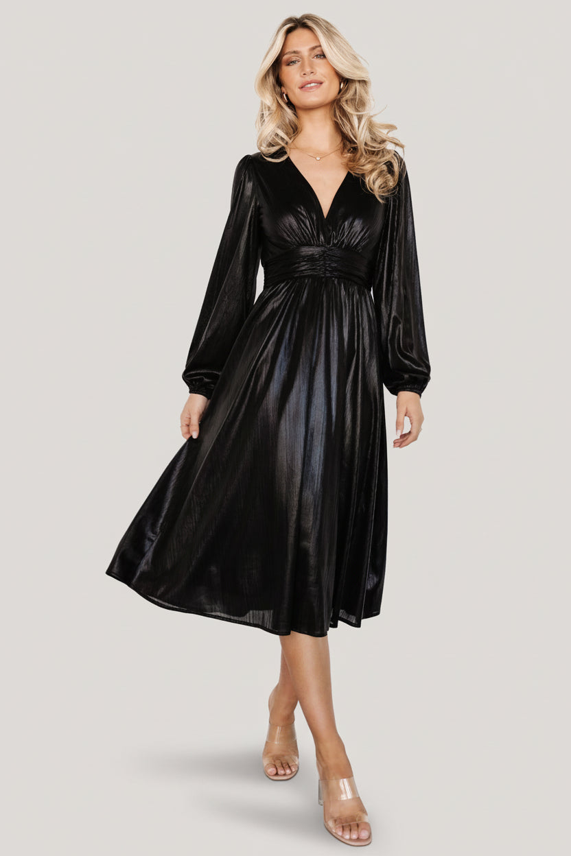 Model wearing Aisha Shimmer Midi Dress in black standing full-length to display overall silhouette, midi hem, and shimmer fabric.