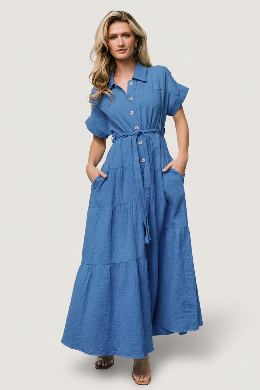Model front view wearing Aizey blue button-up maxi dress in textured cotton, short dolman sleeves, button-front, self-tie sash and hidden pockets.