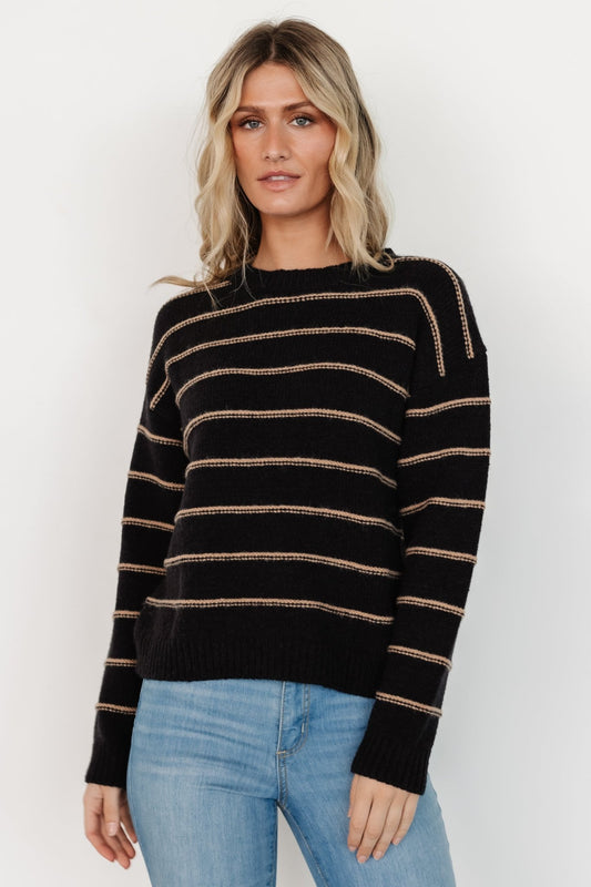 Front view of black sweater with camel raised-knit stripes, round neckline, ribbed cuffs and hem; relaxed fit on model for everyday wear.