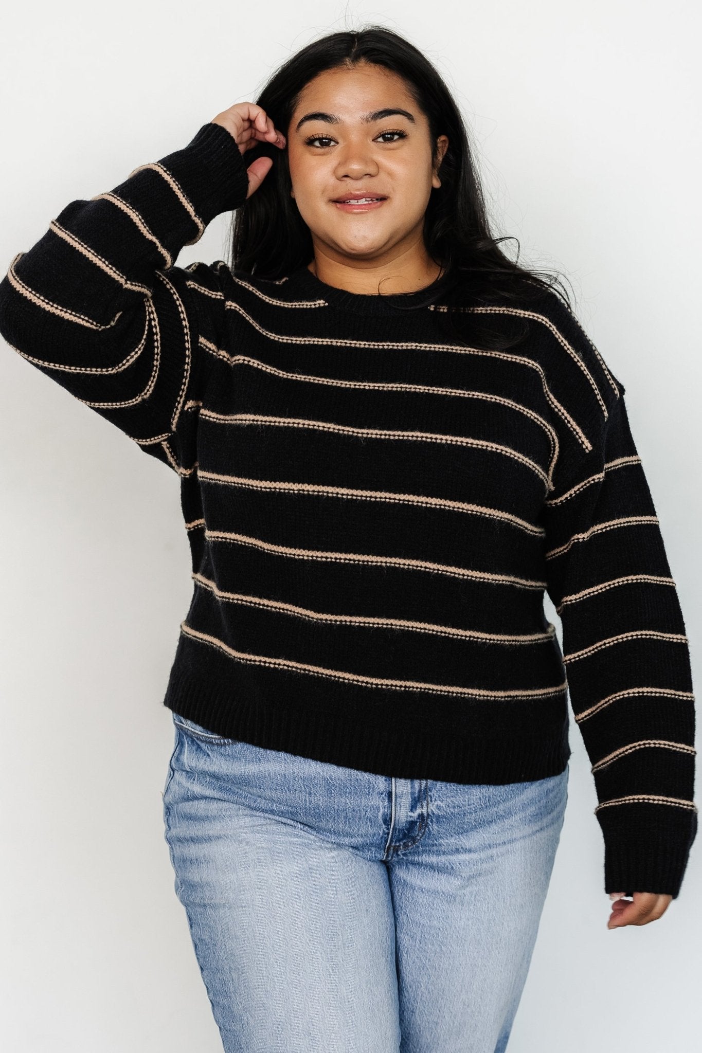 Model wearing the Alanis Stripe Sweater with hands in pockets, demonstrating relaxed fit, round neckline, and everyday styling potential.