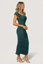 Styled shot of the peacock mesh midi dress on model showing ruched sides, off-shoulder neckline option, structured bust, and poised midi length for formal or celebratory events.