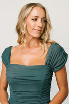 Detail view of peacock mesh fabric and ruching on the Alessandra dress, focusing on texture, seam placement, and how the stretch blend maintains shape across the hip and waist.