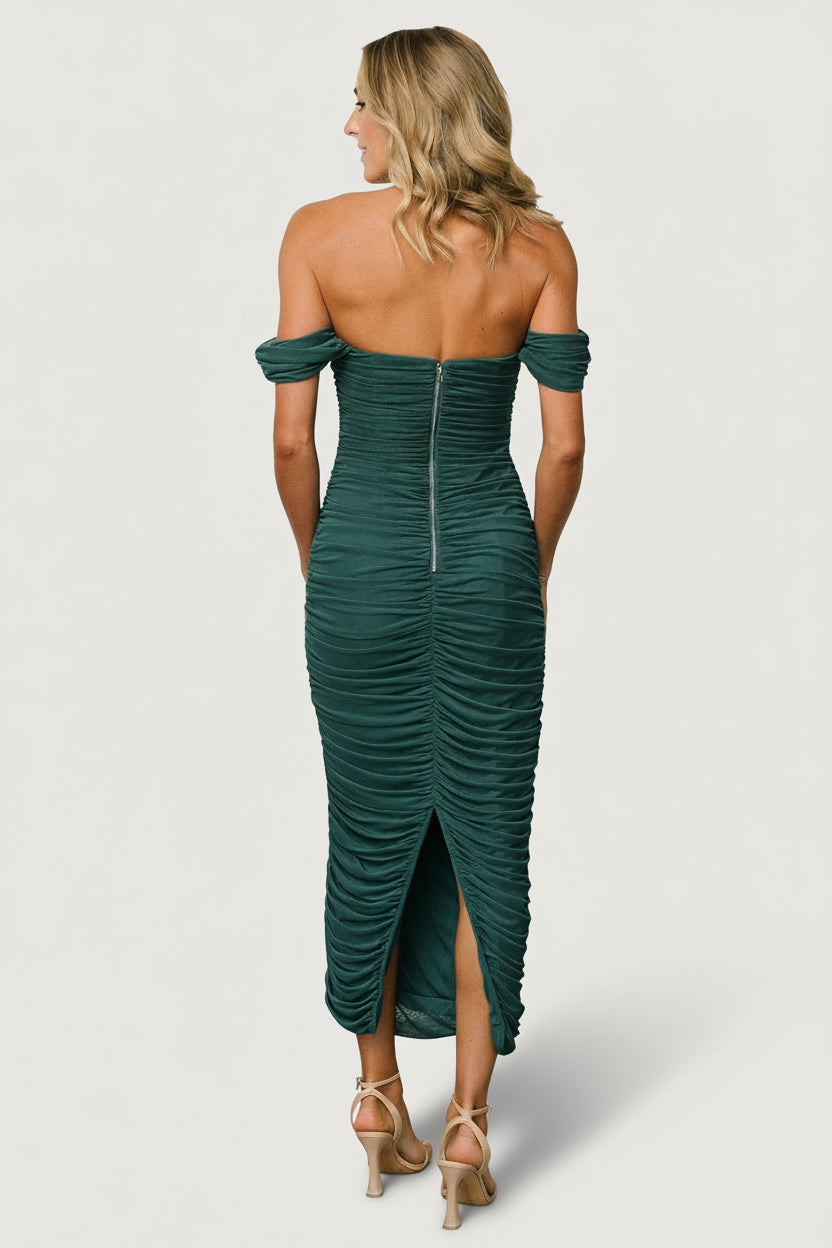Model poses in peacock mesh midi dress with off-shoulder styling; visible zipper at the back, contoured bust, and smooth lining beneath the sheer sleeves for contrast and structure.