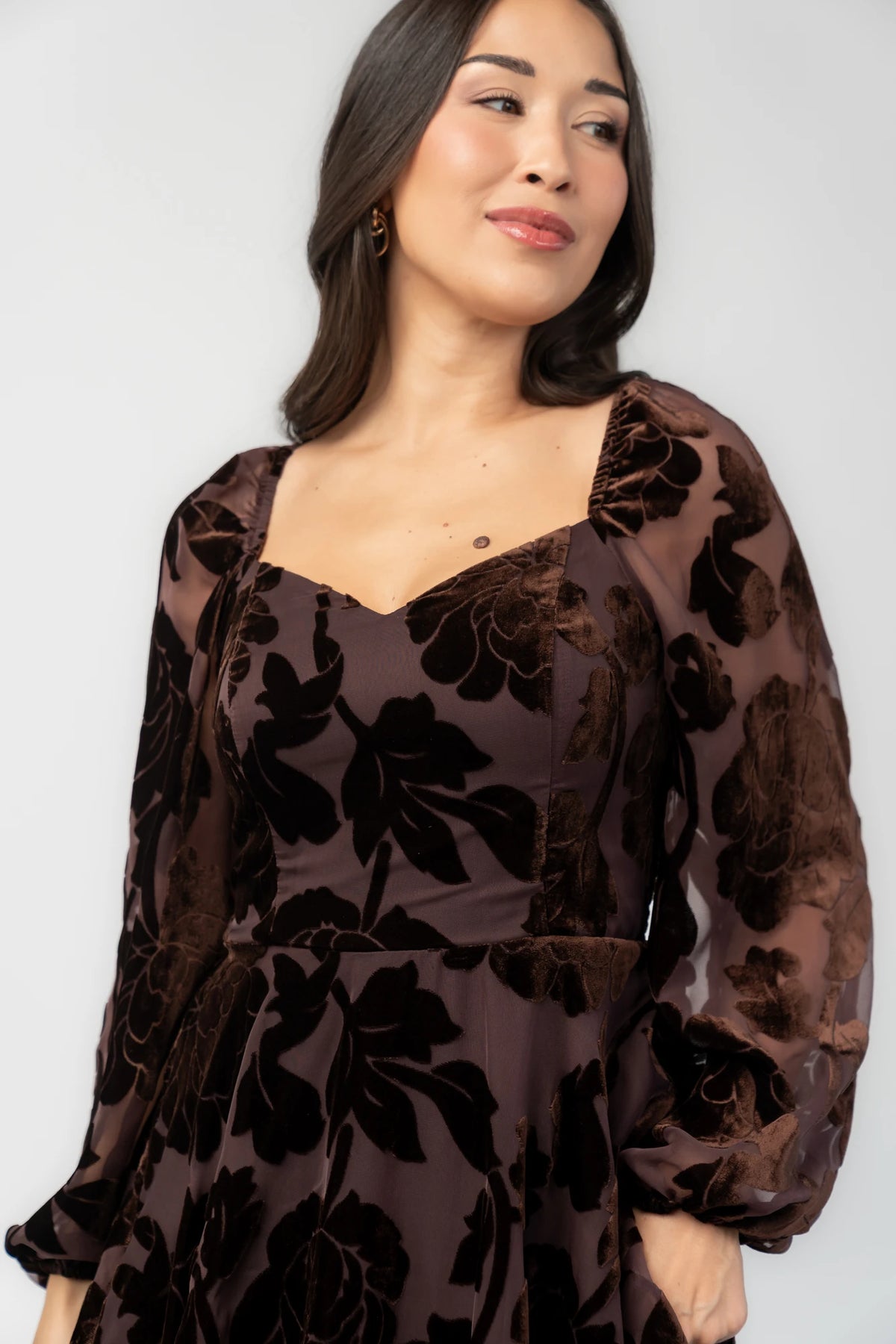 Alexandra Velvet Maxi Dress in Dark Brown with velvet florals, sweetheart neckline, long sleeves, smocked back, and flowing skirt.
