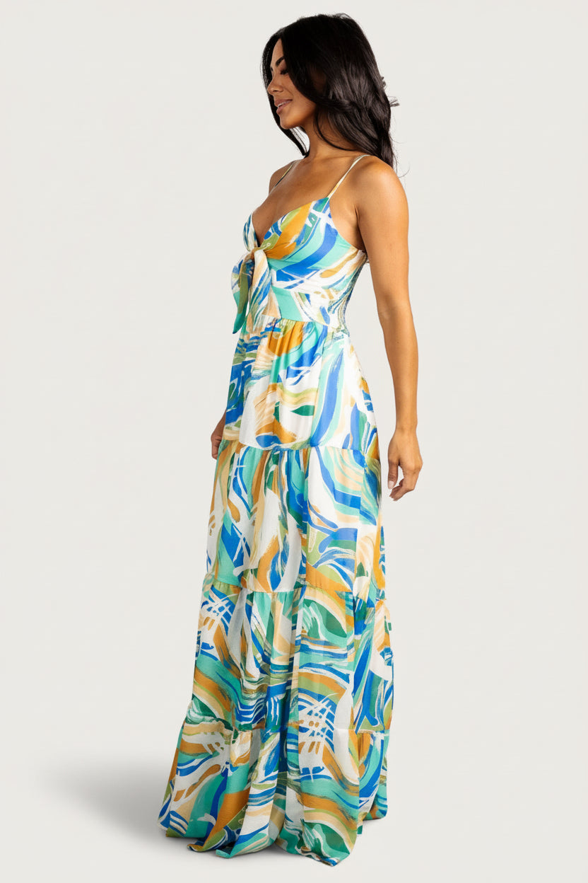 Styled lifestyle shot of the Alexis maxi dress in blue multi print, showing movement of the tiered skirt and feminine silhouette.