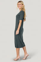 Side profile of Alicia ribbed midi dress in dusty jade, showing the mid-calf length, short sleeves, and how the fabric skims the body.