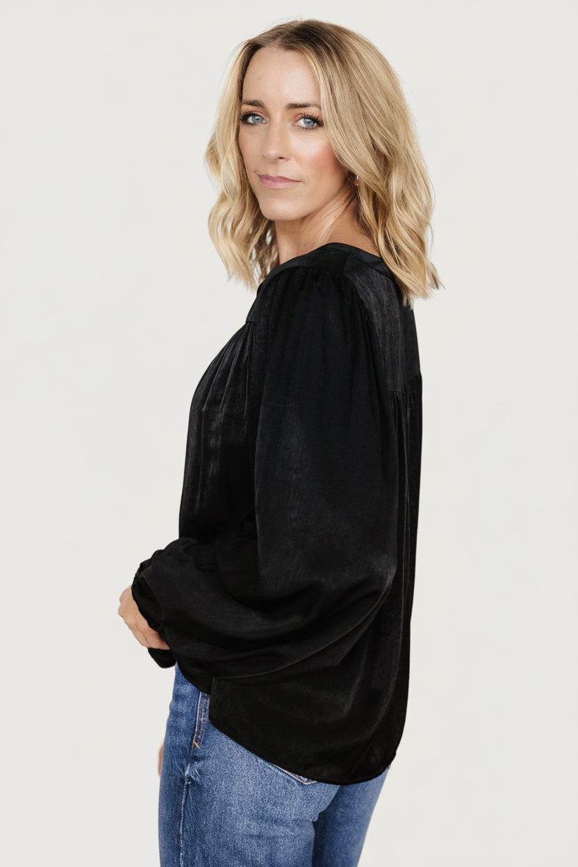 Flat-lay of the Alina blouse in black showing overall silhouette, mandarin neckline, seamed bust detail and the garment's lightweight woven texture.