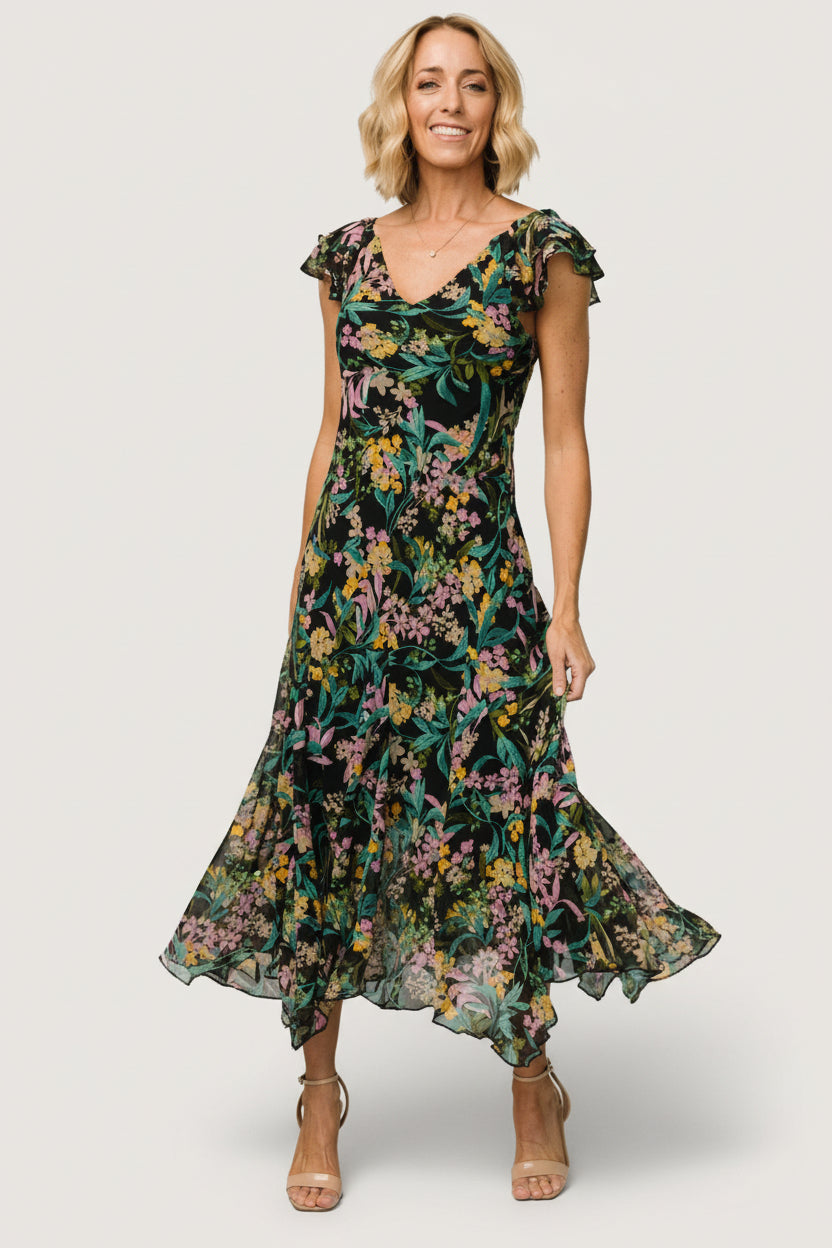 Model movement shot showing the slightly flared maxi skirt in motion, short flutter sleeves, and the dress’s overall flow.