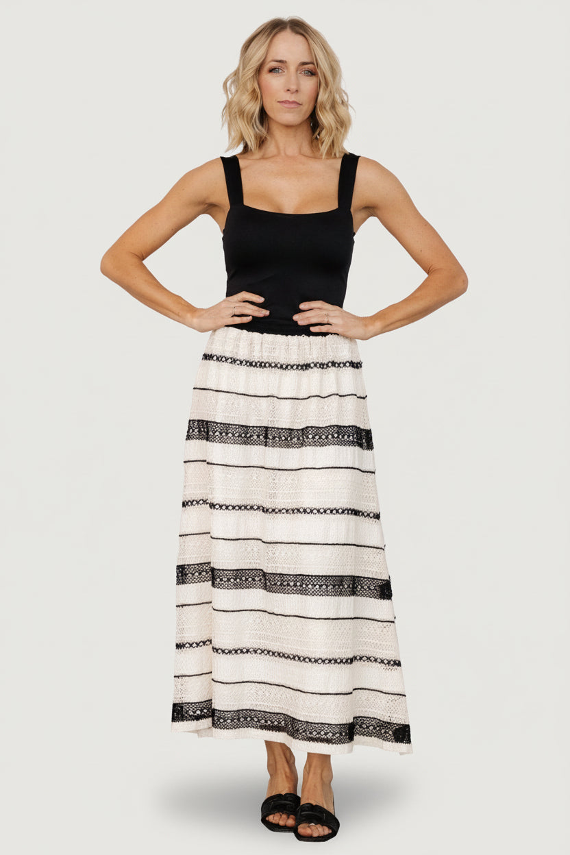 Side view of Alondra A-line skirt in cream and black showing the silhouette, hemline, and elastic waist detail.