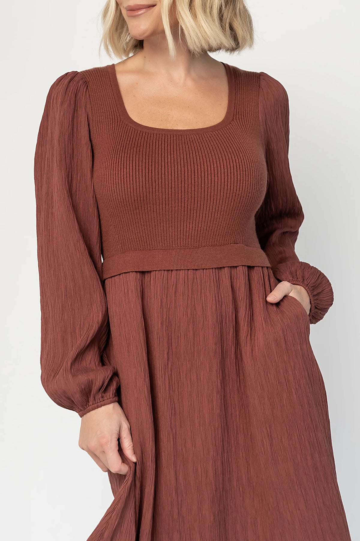 Alva Sweater Dress in Dusty Mahogany with ribbed knit bodice, square neckline, ruffle shoulders, long sleeves, and midi skirt.