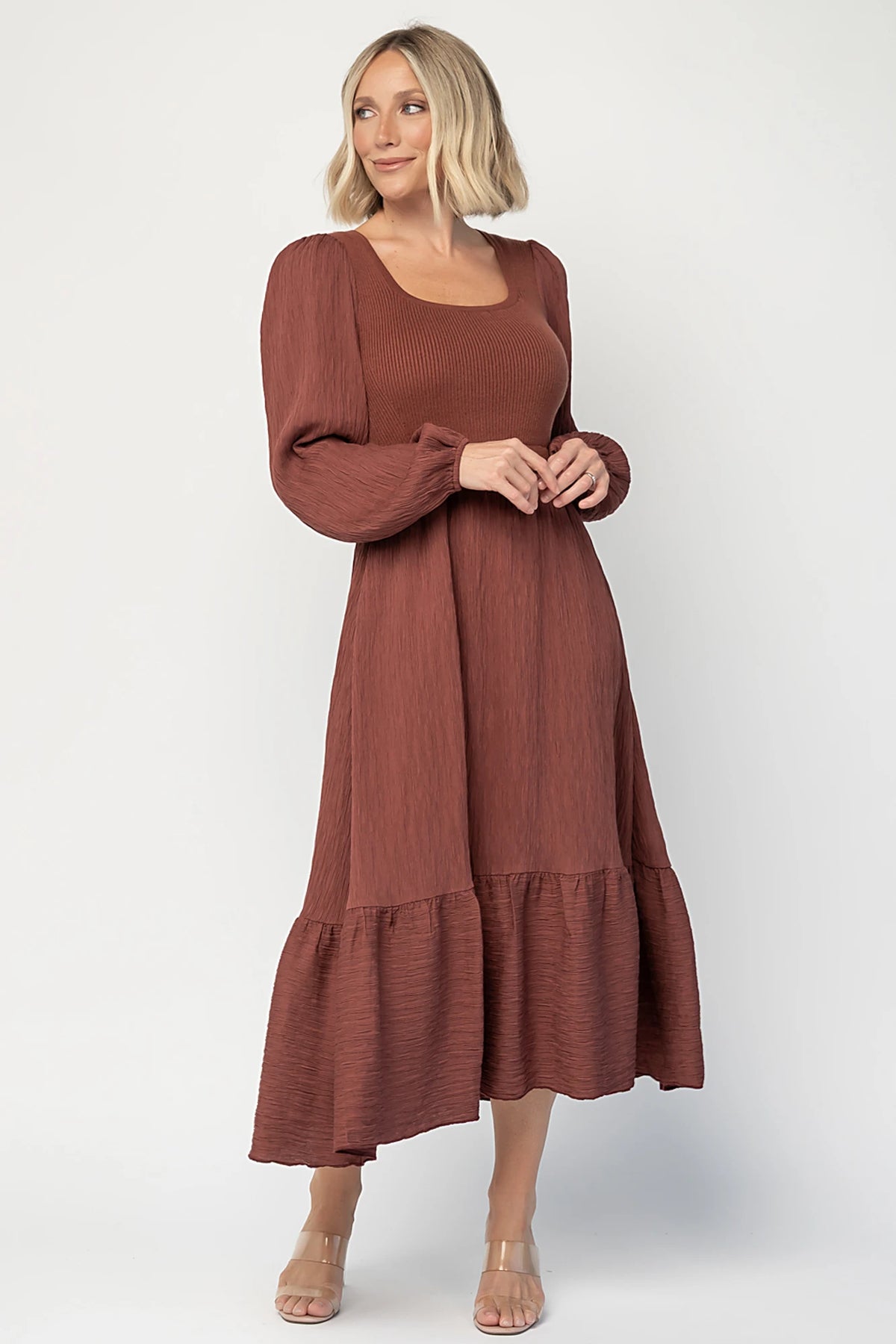 Alva Sweater Dress in Dusty Mahogany with ribbed knit bodice, square neckline, ruffle shoulders, long sleeves, and midi skirt.