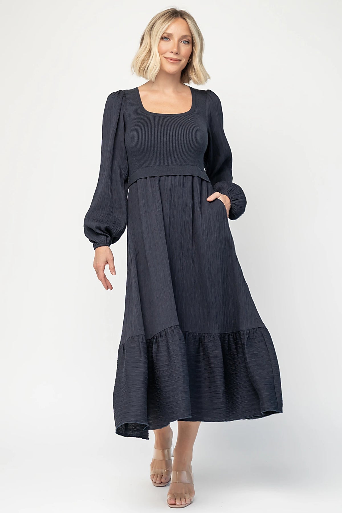 Alva Sweater Dress in Dusty Navy with ribbed knit bodice, square neckline, ruffle shoulders, long sleeves, and midi skirt.
