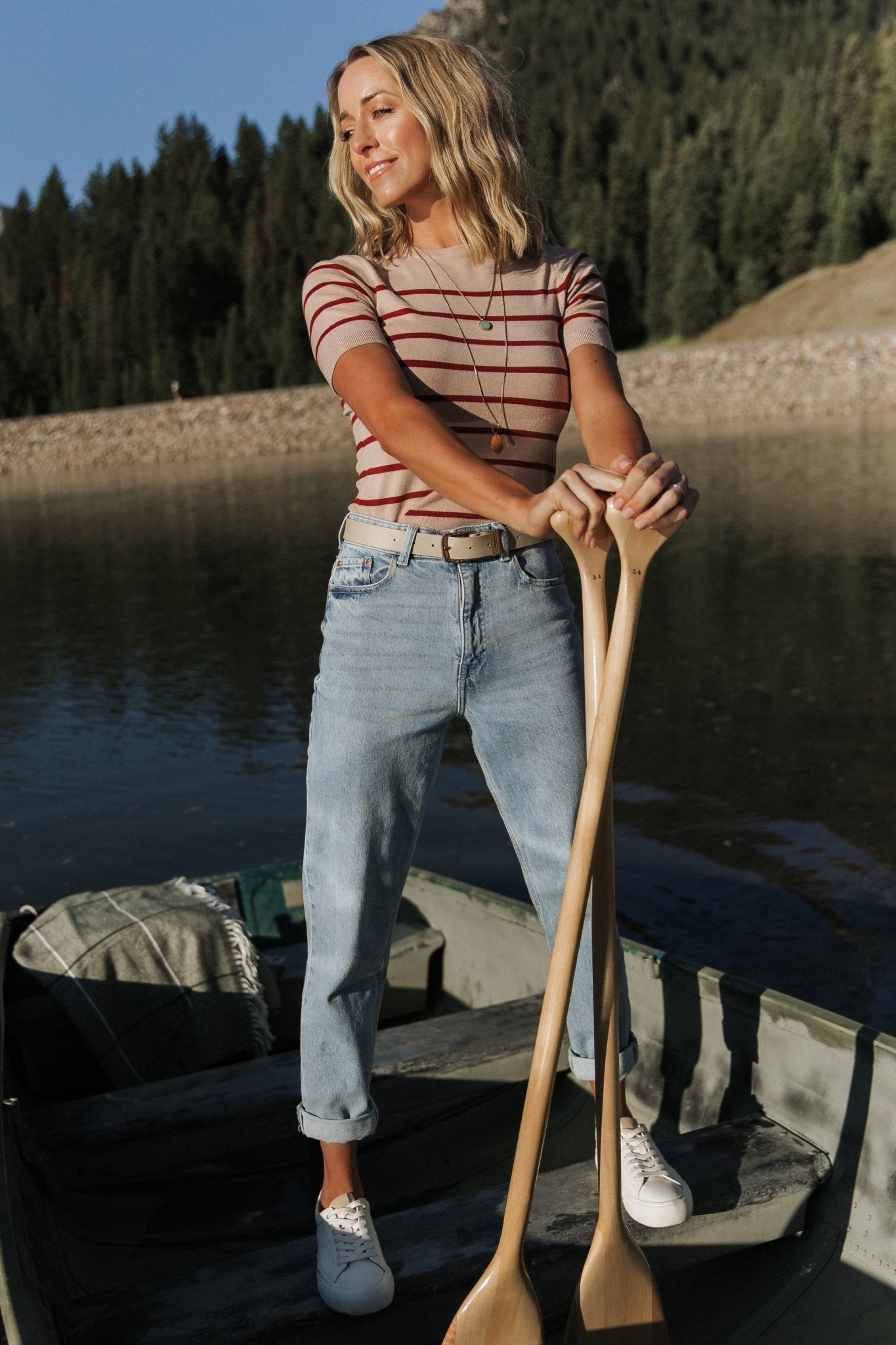 Model seated wearing Alyson Knit Top in oatmeal and rust, demonstrating natural drape, relaxed fit, and how the top layers with outerwear.