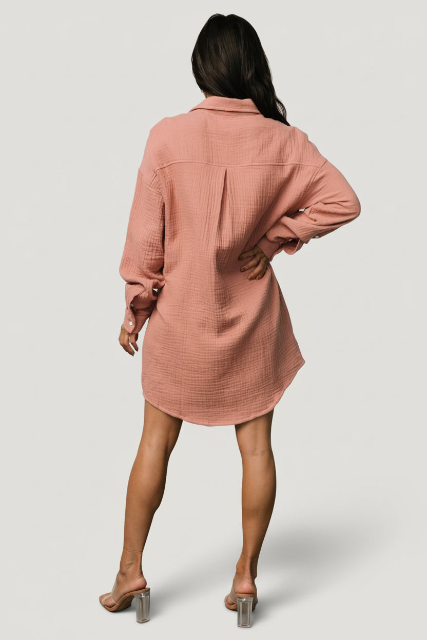 Side view of the Andres Button Shirt Dress in dusty rose demonstrating the drape, asymmetrical hemline, and how the oversized silhouette falls on the body.