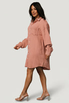 Back and hem detail of the Andres Button Shirt Dress showing the asymmetrical hem, relaxed back drape, and overall silhouette in dusty rose.