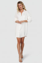 Styled outfit shot of the Andres ivory shirt dress paired with ankle boots, demonstrating versatile everyday styling for travel or casual wear.