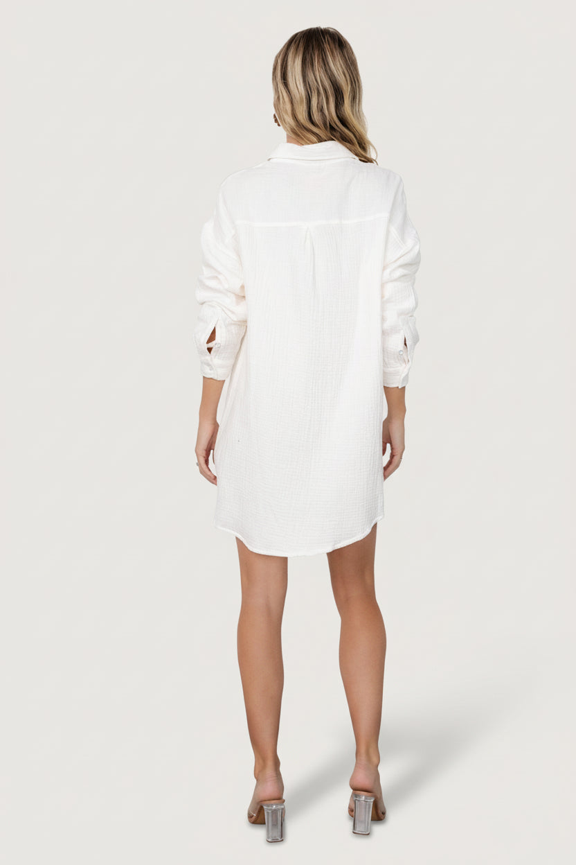 Back view of the Andres ivory shirt dress on model, showing the collared back, clean unlined finish and lightweight drape of the cotton blend.