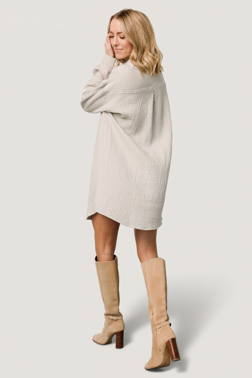 Styled look of light sage button shirt dress paired with boots and accessories, demonstrating day-to-night versatility.