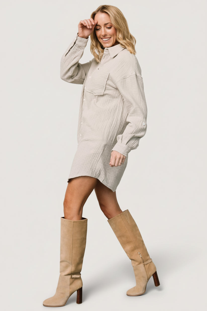 Model wearing light sage oversized shirt dress with sneakers, illustrating casual styling options and asymmetrical hem movement.