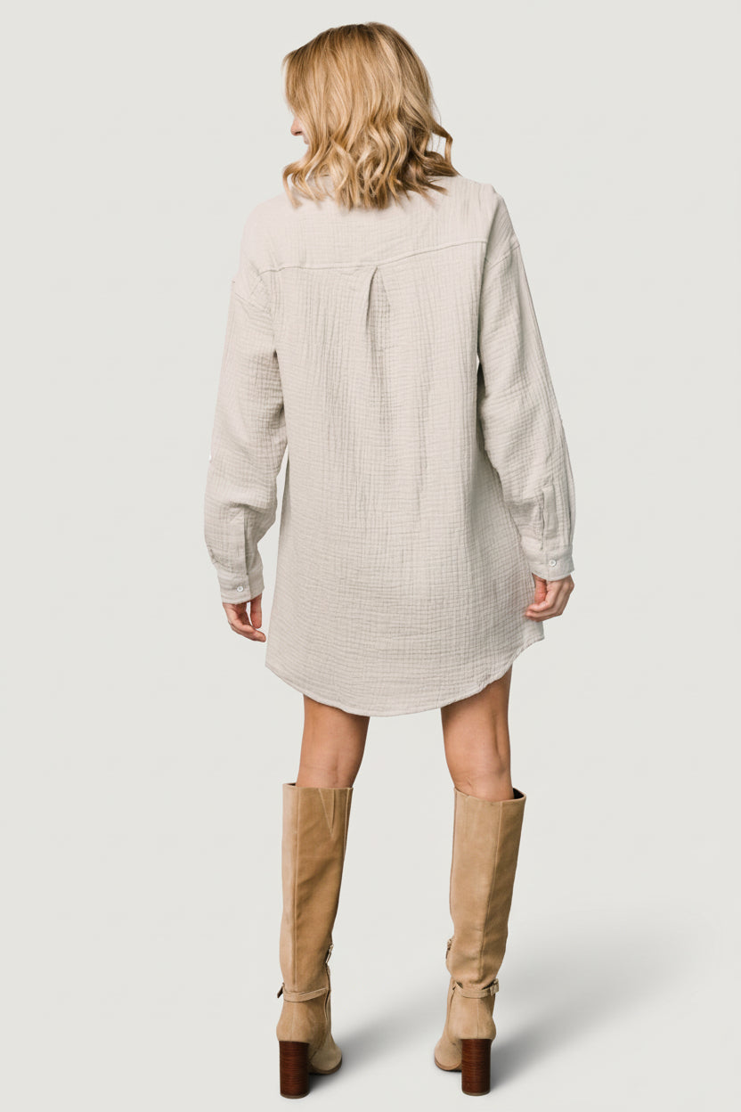 Back view of light sage shirt dress showing relaxed fit, unlined construction, and hemline shape for everyday wear.