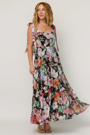 Studio front view of the Anita Maxi Dress in black multi floral showing the square neckline, smocked back, and flowing tiered chiffon skirt.