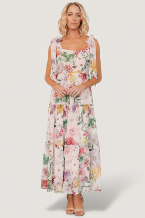 Front view of blush multi floral chiffon maxi dress with square neckline, paneled bodice and three ruffled tiers, fully lined.